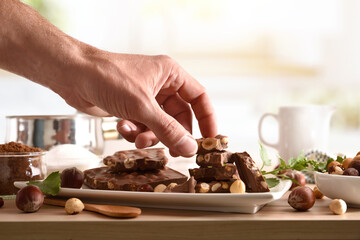 Portions of freshly made chocolate with hazelnuts on kitchen bench - obrazy, fototapety, plakaty