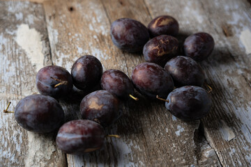 Ripe plums on an old wooden background, horizontal format
