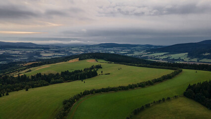 Fototapeta na wymiar Aerial view of Orlicke hory with meadows and forests during cloudy day.