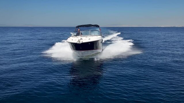 Front view of a sports motor boat cruising with high speed over the blue ocean
