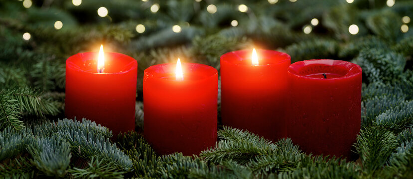 Red Advent candles, three burning, with fir branches and bokeh lights. The image is part of a set.