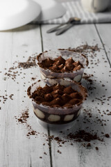 Italian tiramisu dessert in a glass. on a white wooden table. dessert, snack