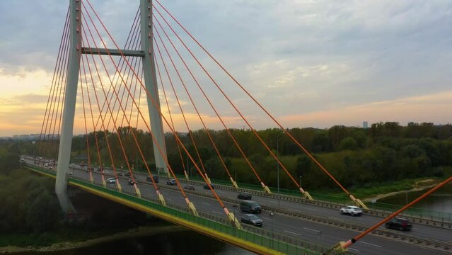 Aerial view of the Siekierki (Siekierkowski) transport bridge over the Vistula (Wisła) river, on which cars move. In the background Warsaw city urban skyline.