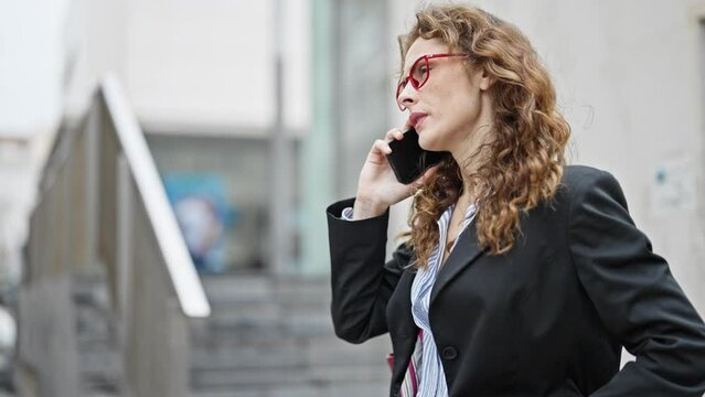 Young woman business worker talking on smartphone looking watch at street