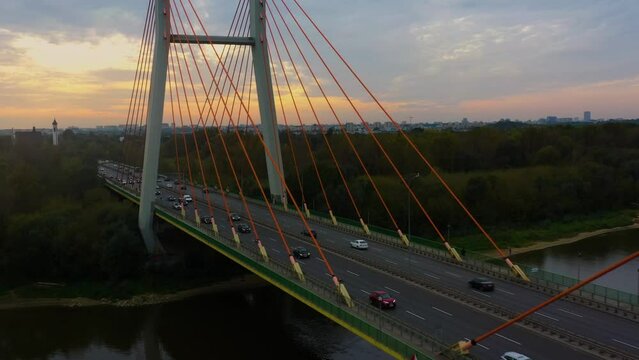 Aerial view of the Siekierki (Siekierkowski) transport bridge over the Vistula (Wisła) river, on which cars move. In the background Warsaw city urban skyline.