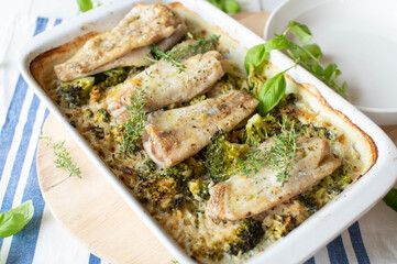 Baked fish fillets  with creamy brown rice and broccoli in a baking dish
