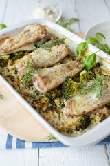 Baked fish with creamy brown rice and broccoli in a baking dish