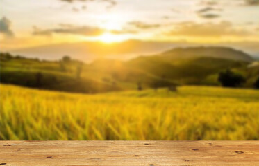 Wooden table top on blur rice field and mountain background.For place food,drink or health care...