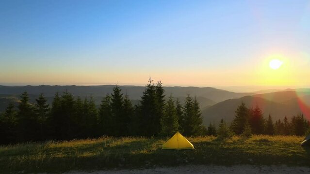 Camping tent at mountain campsite on bright sunny evening. Active tourism and hiking concept