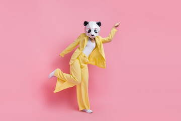 Full size photo of classy weird 3d panda mask girl point finger empty space dancing isolated on...