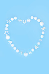 Christmas heart shape wreath. White snowflakes, stars and balls. Romantic symbol for holiday season on blue background. Festive symbol for greeting card, menu, invitation, logo.