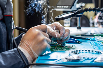 Cutting-edge electronics workshop scene showcases a skilled technician's hands meticulously...