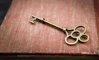 Key on an old book. Top secret, confidential or classified background.