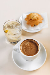 Cup of coffee with water and a cupcake.