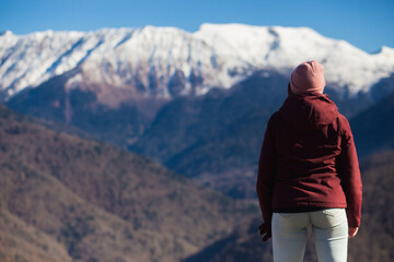 Naklejka premium A young woman admires the mountain views in winter