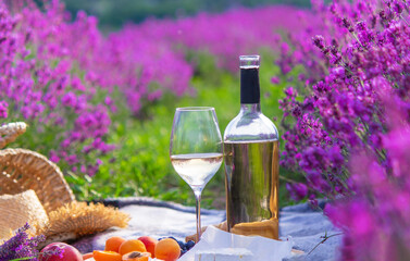 wine, fruits, berries, cheese, glasses picnic in lavender field Selective focus