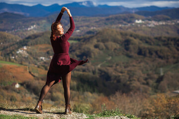 Beautiful curvy woman in red dress posing in autumn mountains