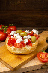 Greek dish dakos with tomatoes and olives, vertical photo.