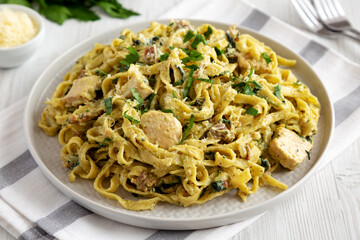 Homemade Creamy Chicken Bacon Pesto Pasta on a Plate, side view.