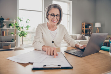 Photo of dreamy sweet senior lady assistant dressed white cardigan preparing document modern gadget indoors house room