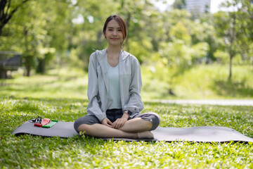 Young Asian woman revitalized through park yoga, meditation, aligning body, mind, restoring energy.