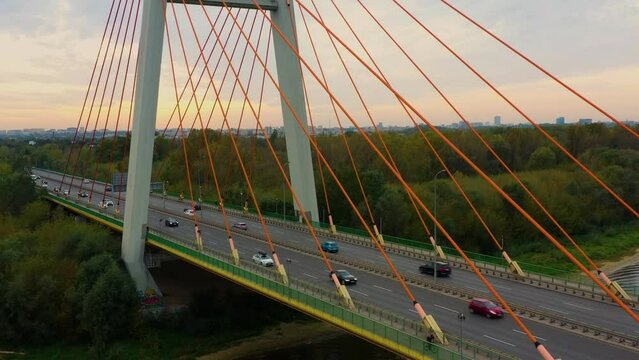Aerial view of the Siekierki (Siekierkowski) transport bridge over the Vistula (Wisła) river, on which cars move. In the background Warsaw city urban skyline.