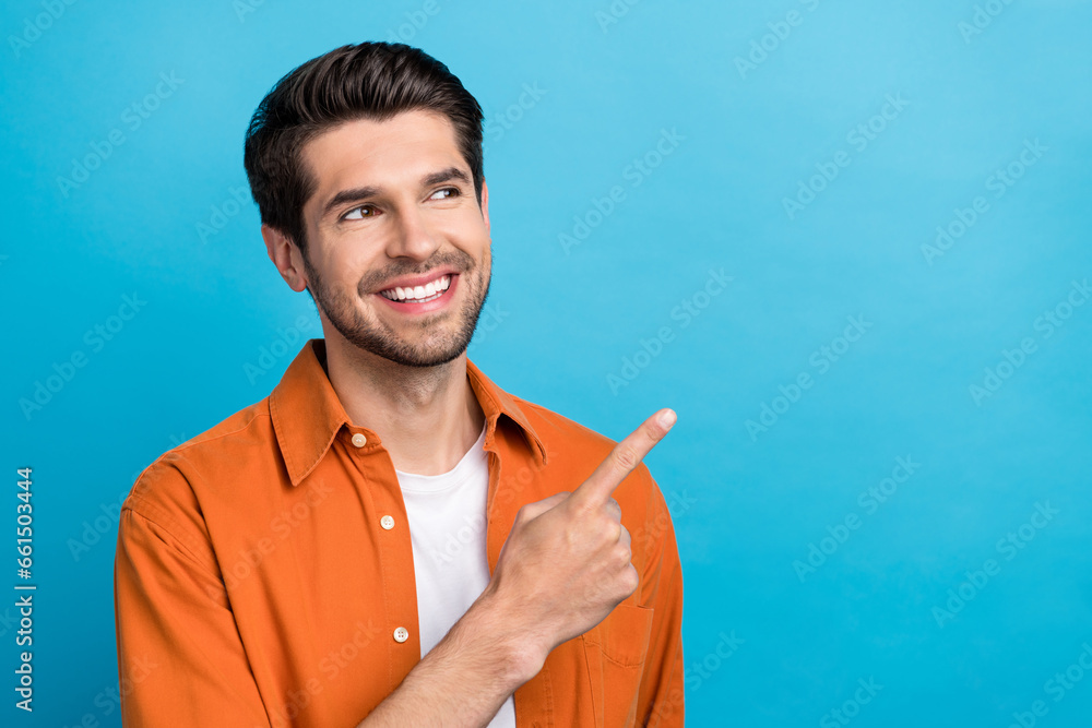Poster portrait of positive friendly person beaming smile look direct finger empty space isolated on blue c