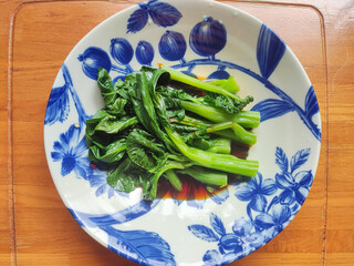 fresh braised green vegetables in the blue plate for eating
