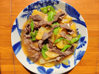 beef slice scrambled with potatoes and green vegetables on the blue plate for eating - Powered by Adobe