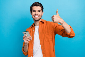 Portrait of handsome cheerful guy hold iphone apple gadget toothy smile demonstrate thumb up...