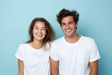 Fotobehang Young fictional white couple smiling. Isolated on a plain blue background. Generative AI. © Tuyres