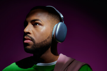 good looking bearded man in green sweatshirt with headphones looking away, fashion concept