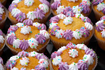 lose up of homemade muffins decorated with colorful creamy flowers