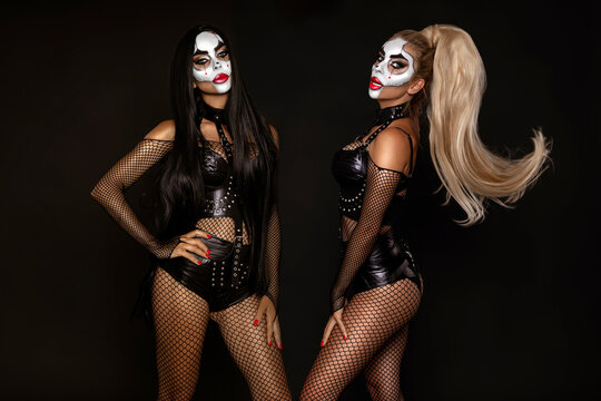 Sexy woman in a Halloween makeup and latex costume on black background. Halloween makeup and costume concept.