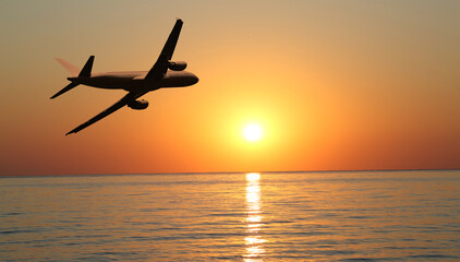 plane takes off at sunrise over the sea 