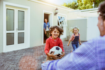 Young children running to the arms of their absent father in the driveway