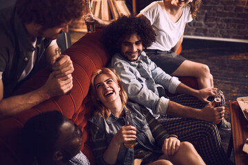 Diverse group of friends having drinks on the couch at home
