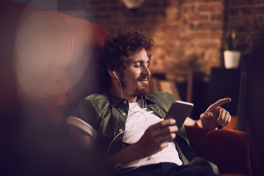 Young man listening to music on a smartphone at home