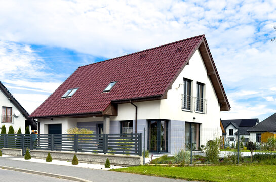 Elegant single family house in Poland seen from the street, fence and roof as main features.