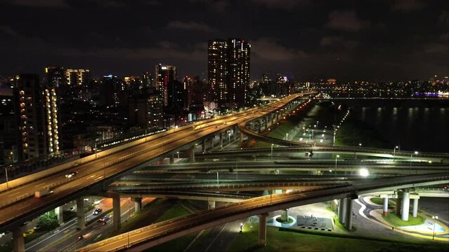 Aerial 4k video of Xinbei bridge at night. Cars passing through the bridge with colorful lights. New Taipei City, Xindian Sunshine Sports Park Sunshine Bridge.