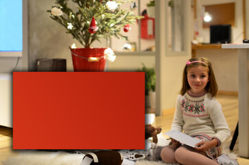 Little girl sitting on the floor in front of a fireplace with a red board