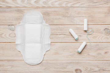 women pads and tampon - sanitary pads lies next to a tampon on an isolated background on a pink and...