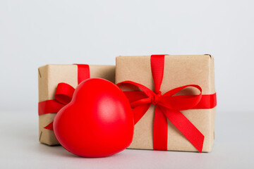 gift box with red bow and red heart on colored background. Perspective view. Flat lay