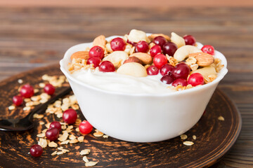 Healthy breakfast food with granola, yogurt, fruits and nuts. Dessert parfait with dried fruits for...