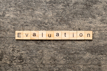 evaluation word written on wood block. evaluation text on table, concept