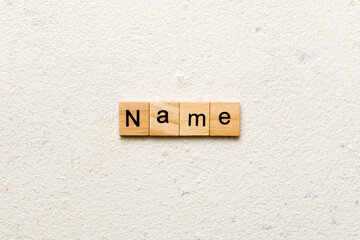 NAME word written on wood block. NAME text on cement table for your desing, concept