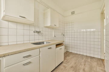 a very clean kitchen with white cabinets and wood flooring in the photo is taken to the right, it's not clear