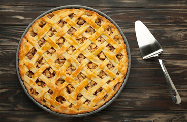 Homemade sweet american apple pie with sugar and cinnamon. Tart on brown background.
