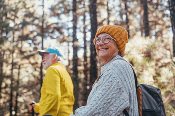 Portrait close up head shot of one cheerful smiling middle age woman walking with her husband enjoying free time and nature. Active beautiful seniors in love together at sunny day.. - Powered by Adobe
