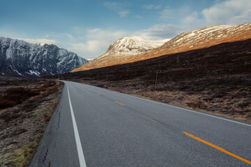 View of a road on high altitude leading through the norweigian mountains in autumn.